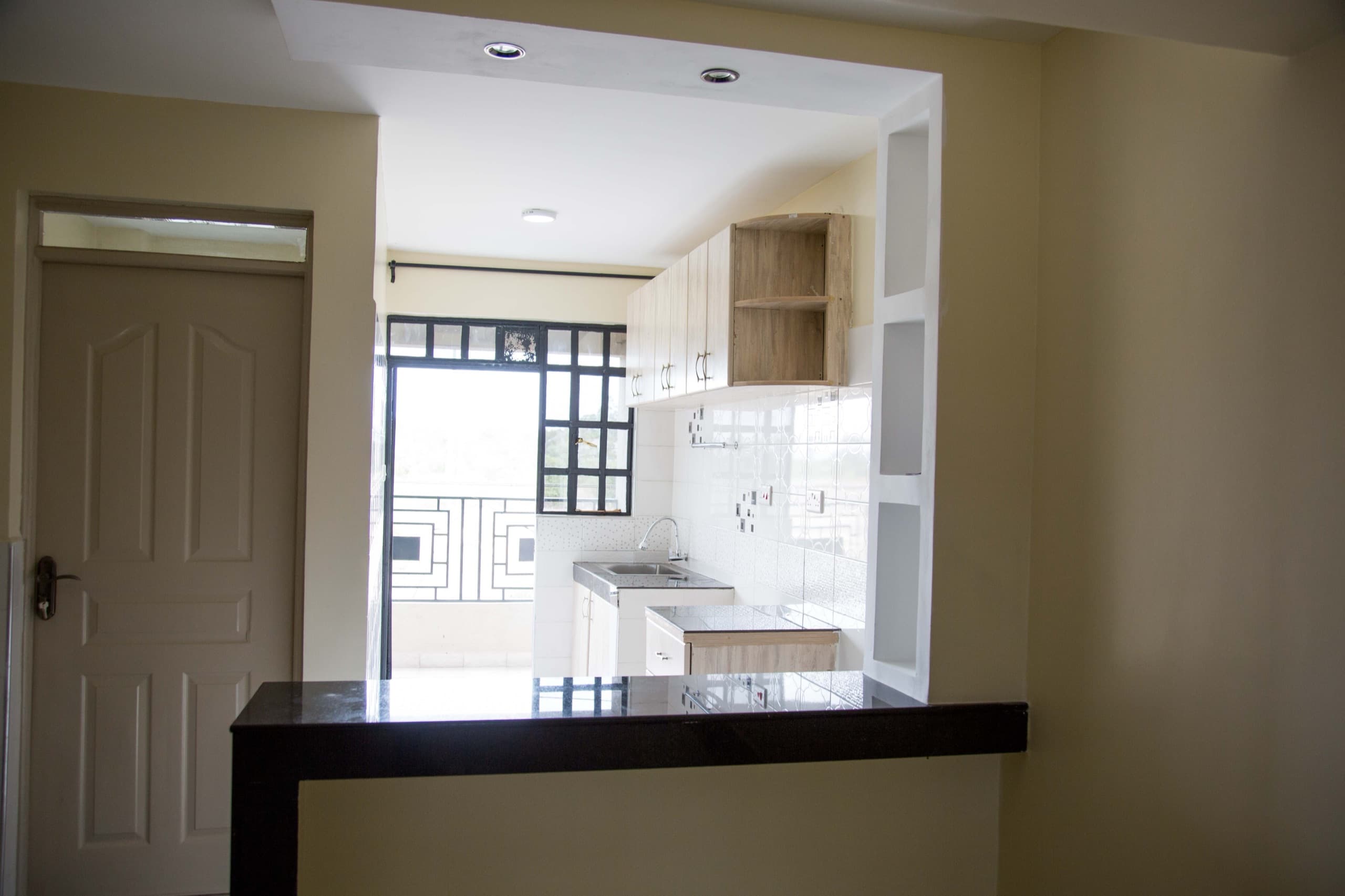 Open-plan kitchen with breakfast bar in a completed Milans by KCiti home